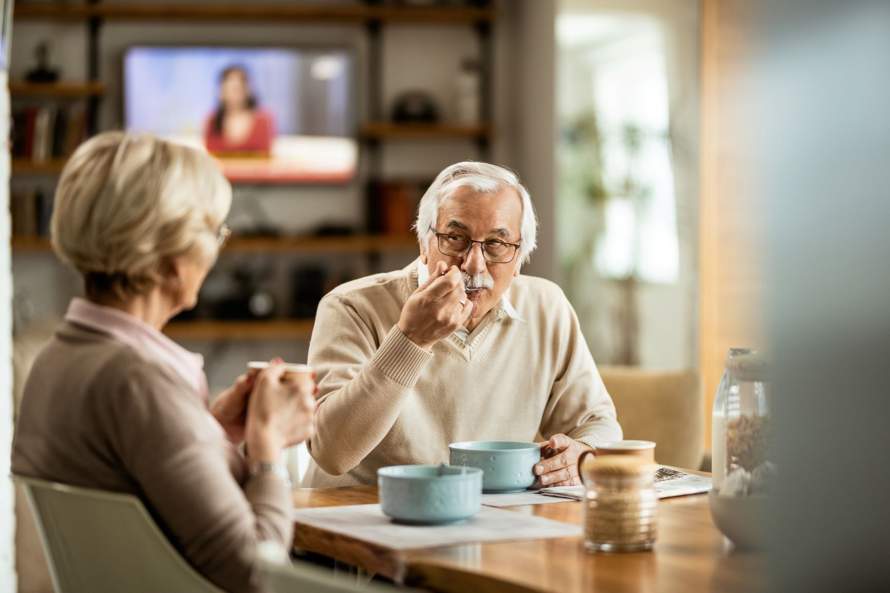 Oudere man en vrouw aan de ontbijttafel